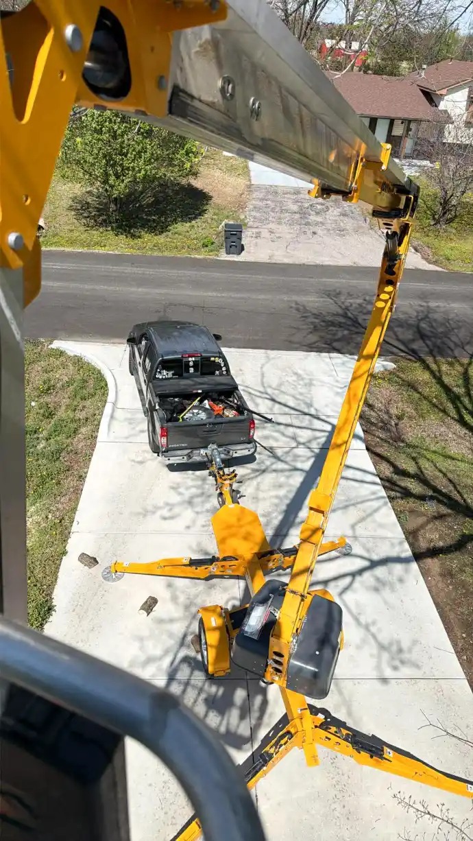 Aerial view from our specialized bucket lift showing our service truck and equipment setup for high-reach tree trimming in Sedgwick County.