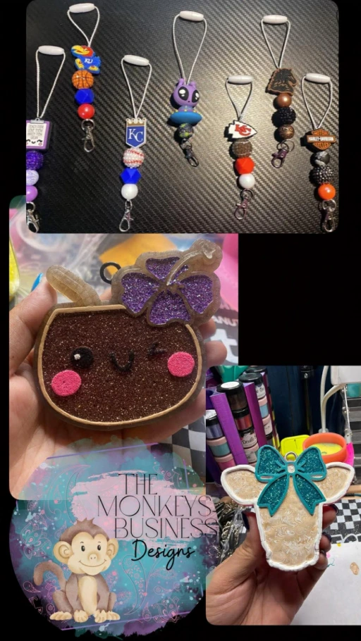 A high-resolution display of Monkey’s Business Designs "freshies"—vibrant, hand-crafted car air fresheners in various custom shapes and colors, featuring glitter accents, fringe tassels, and intricate beaded hangers.